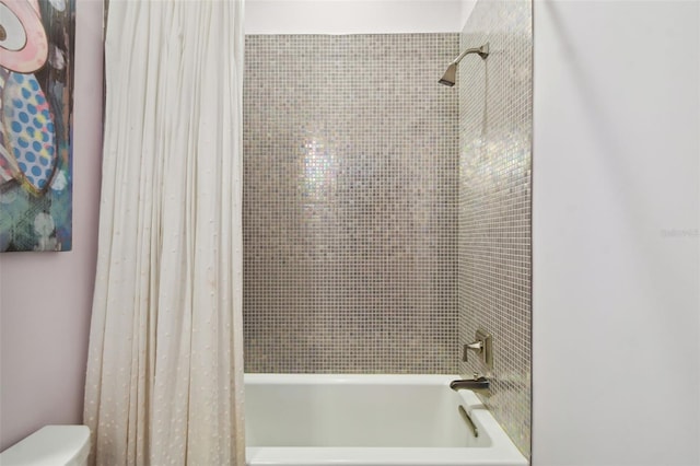 bathroom featuring shower / bath combo and toilet