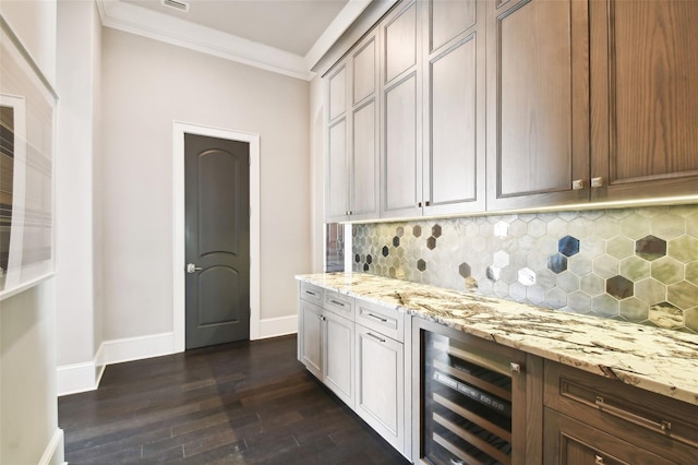 bar with backsplash, light stone counters, ornamental molding, dark wood-type flooring, and wine cooler