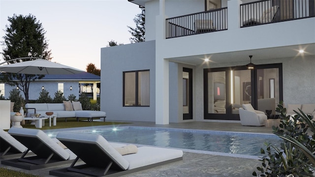 pool at dusk featuring an outdoor living space and a patio area