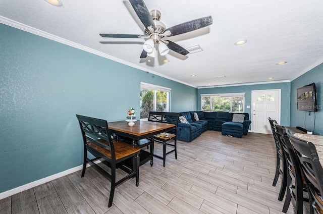 dining space with ceiling fan and crown molding