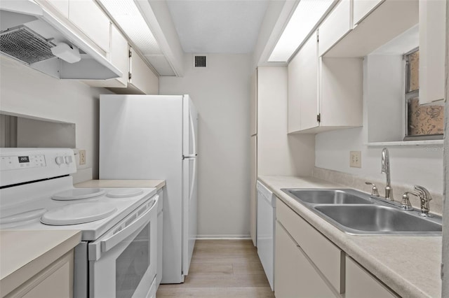 kitchen featuring white cabinetry, sink, light hardwood / wood-style floors, and white appliances