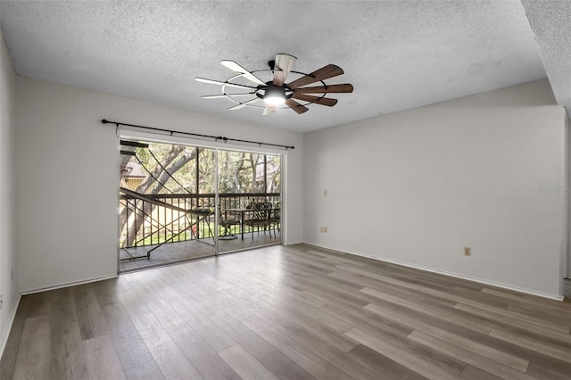 spare room featuring wood-type flooring, a textured ceiling, and ceiling fan