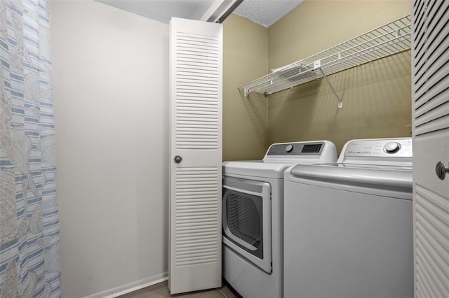 laundry room featuring separate washer and dryer and a textured ceiling