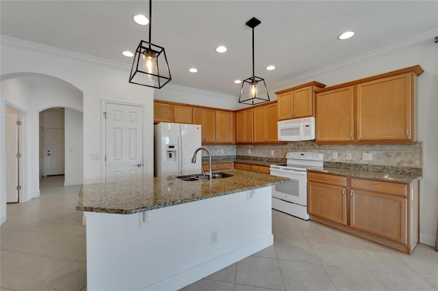 kitchen with white appliances, a center island with sink, sink, hanging light fixtures, and tasteful backsplash