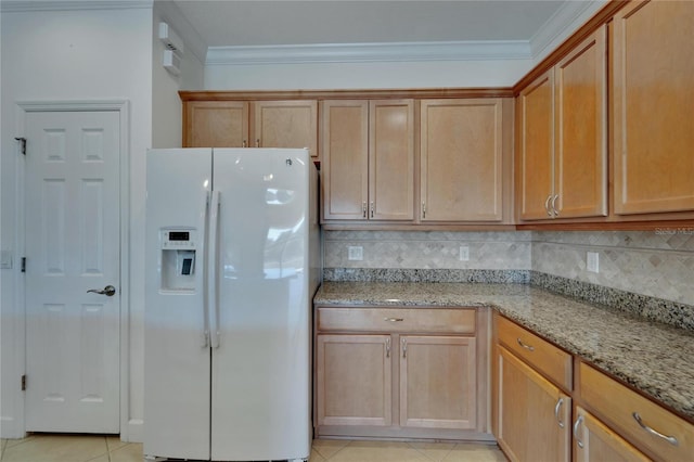 kitchen with tasteful backsplash, light stone counters, ornamental molding, light tile patterned floors, and white fridge with ice dispenser