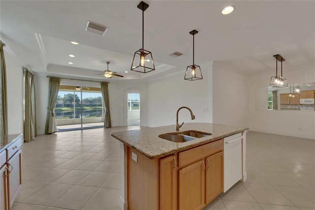 kitchen with white appliances, a kitchen island with sink, hanging light fixtures, sink, and a tray ceiling