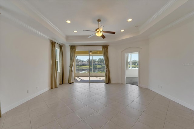 empty room with a tray ceiling, ceiling fan, and crown molding