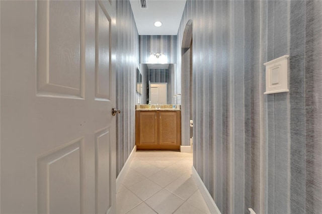 hallway featuring light tile patterned flooring and sink