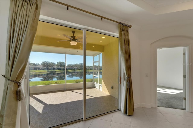 doorway to outside featuring ceiling fan, a water view, and light tile patterned floors