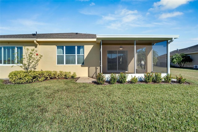 rear view of property featuring a lawn and a sunroom