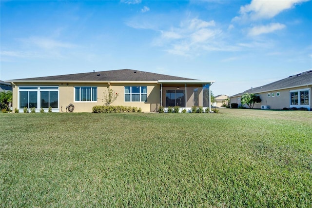 back of property featuring a sunroom and a yard