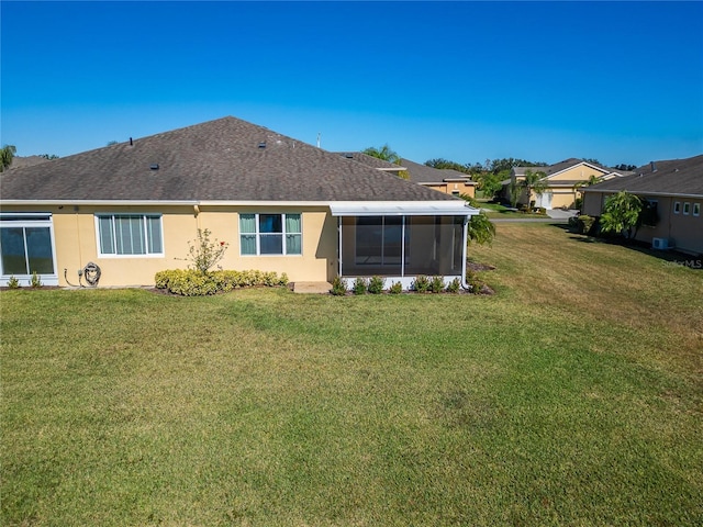 rear view of property with a sunroom and a yard