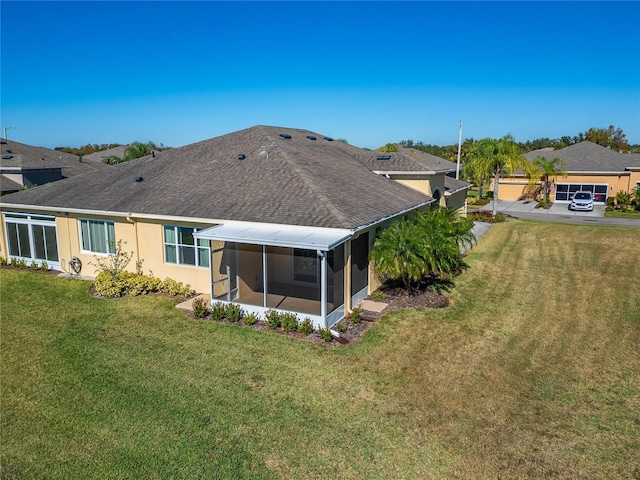 rear view of property with a sunroom and a yard