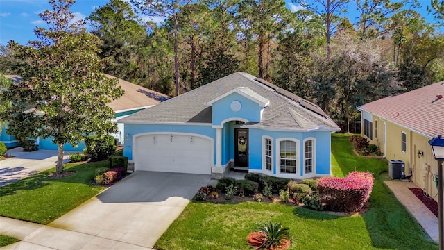 view of front of home featuring a front yard, solar panels, a garage, and central AC unit