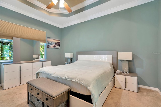 carpeted bedroom with a raised ceiling, ornamental molding, and ceiling fan