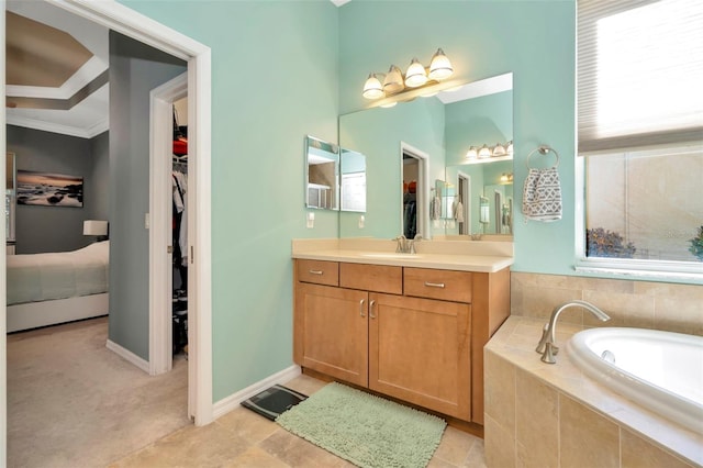 bathroom with tiled tub and vanity