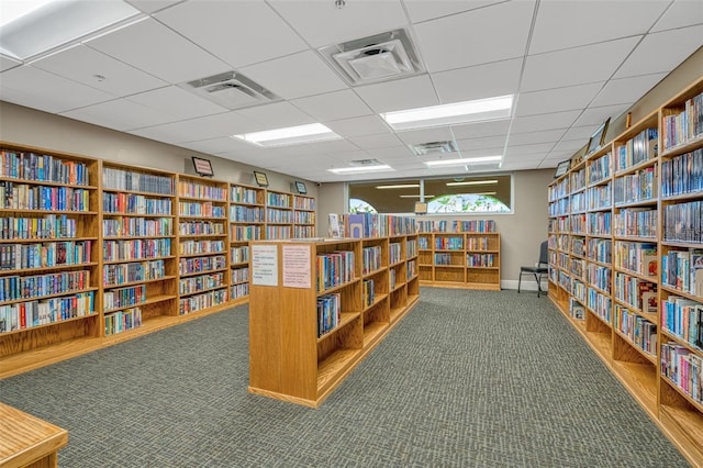 interior space with a drop ceiling and carpet flooring