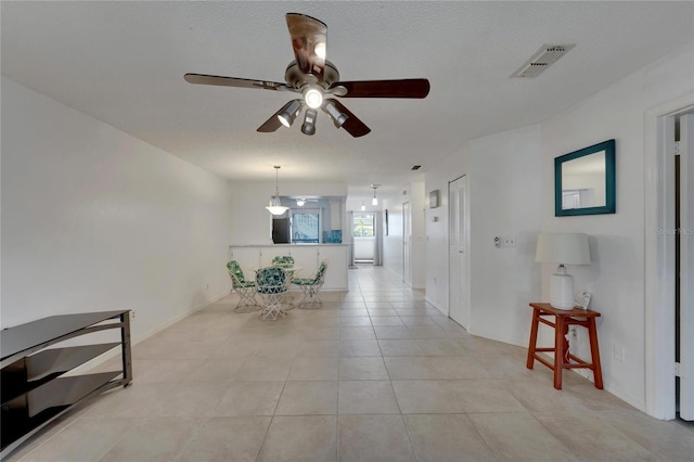 hall with light tile patterned floors and a textured ceiling