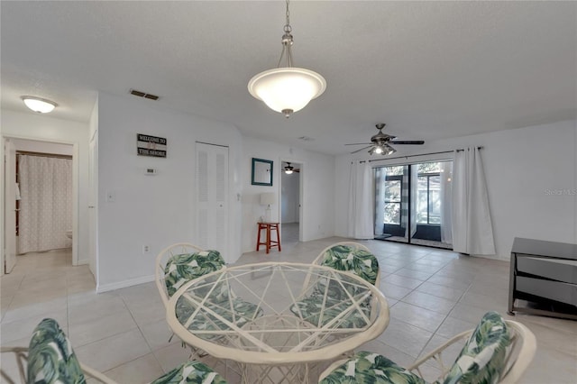 dining area with ceiling fan, light tile patterned flooring, a textured ceiling, and french doors