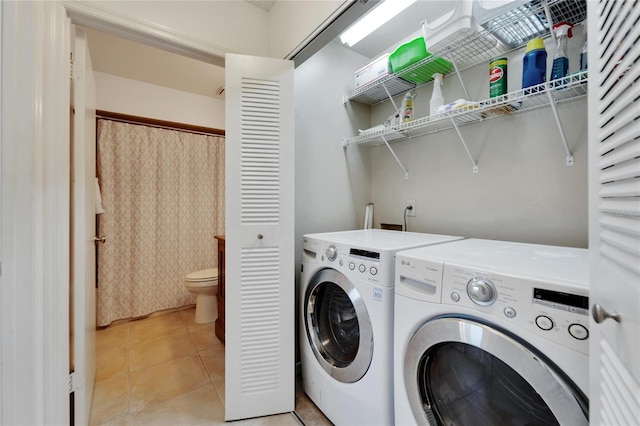 clothes washing area featuring washing machine and dryer and light tile patterned floors