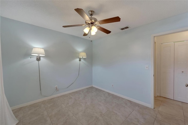 empty room with a textured ceiling and ceiling fan