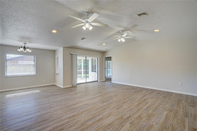 11339 Gulfstream Blvd, Port Charlotte, FL 33981 - empty room with a textured ceiling, wood finished floors, a chandelier, ceiling fan, and vaulted ceiling