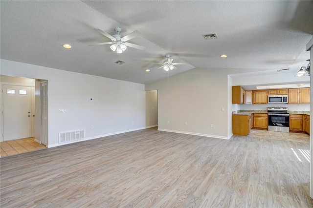 unfurnished living room featuring ceiling fan, lofted ceiling, a textured ceiling, and light hardwood / wood-style flooring