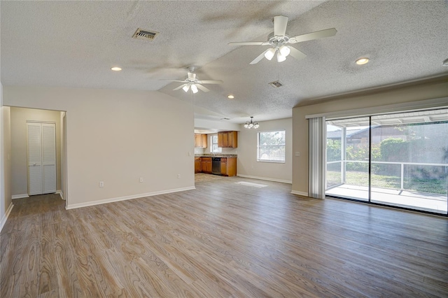 11339 Gulfstream Blvd, Port Charlotte, FL 33981 - unfurnished living room with light wood-style flooring, ceiling fan, a textured ceiling, lofted ceiling, and a chandelier
