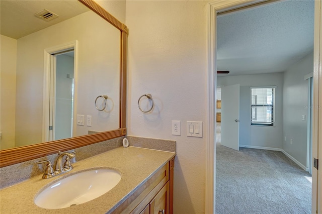 bathroom featuring a textured ceiling and vanity