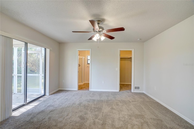 11339 Gulfstream Blvd, Port Charlotte, FL 33981 - unfurnished bedroom with access to outside, carpet flooring, a textured ceiling, a walk in closet, and ensuite bath