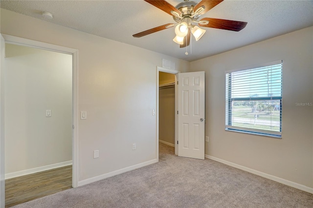 11339 Gulfstream Blvd, Port Charlotte, FL 33981 - unfurnished bedroom with a walk in closet, carpet, ceiling fan, a textured ceiling, and a closet