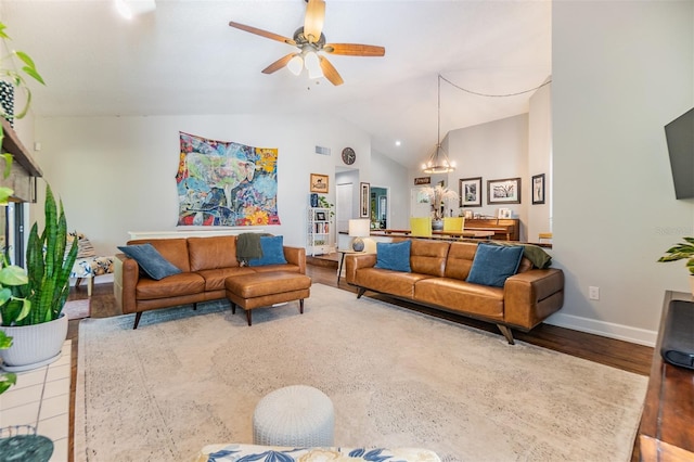 living room featuring ceiling fan with notable chandelier, light hardwood / wood-style flooring, and vaulted ceiling