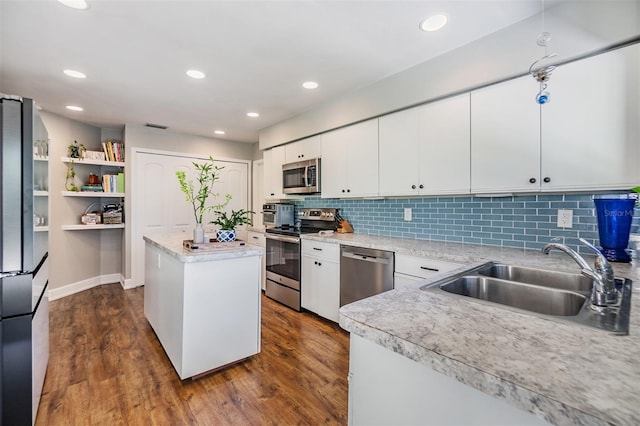 kitchen with a center island, white cabinets, sink, dark hardwood / wood-style floors, and appliances with stainless steel finishes