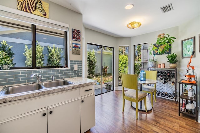 kitchen featuring tasteful backsplash, sink, white cabinets, and light wood-type flooring