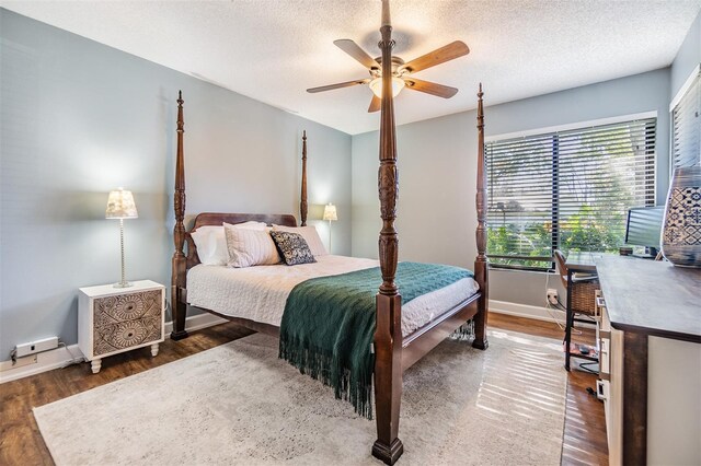 bedroom with ceiling fan, dark hardwood / wood-style floors, and a textured ceiling