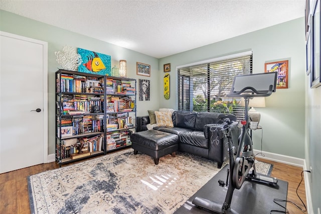 exercise room featuring hardwood / wood-style floors and a textured ceiling