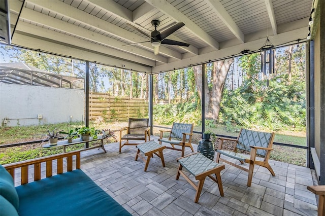 sunroom featuring ceiling fan, beamed ceiling, and a healthy amount of sunlight