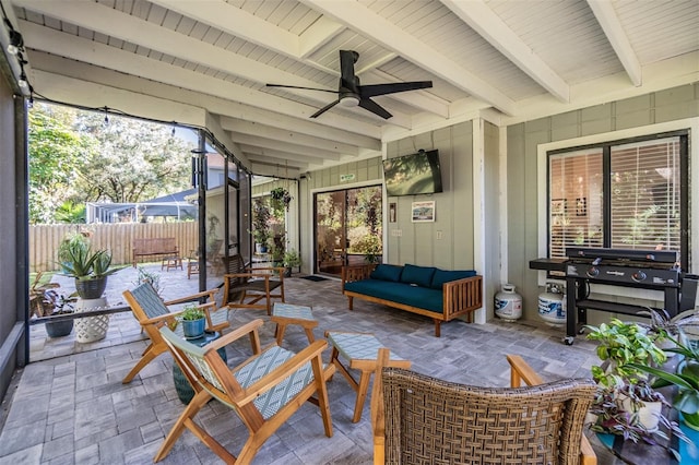 sunroom featuring beam ceiling and ceiling fan