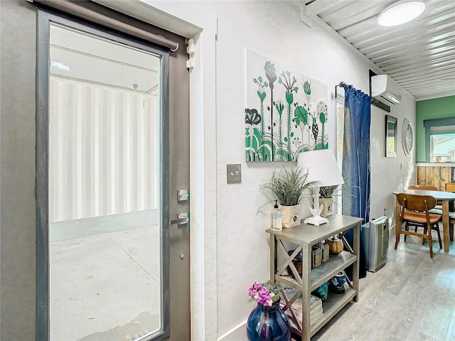 doorway featuring light wood-type flooring and a wall unit AC