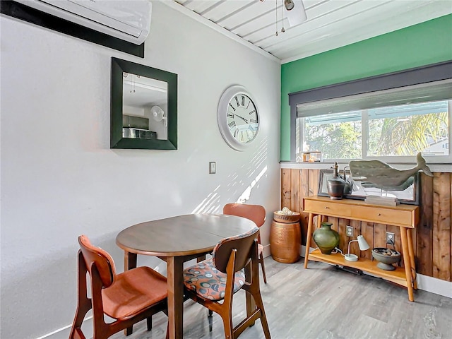 dining area featuring hardwood / wood-style flooring, crown molding, and a wall mounted AC