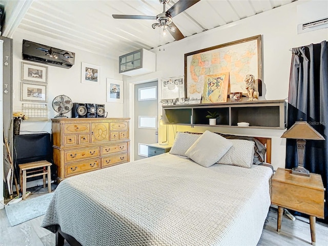 bedroom with ceiling fan, light wood-type flooring, and an AC wall unit