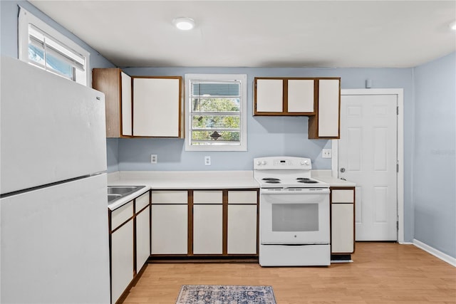 kitchen featuring plenty of natural light, white cabinetry, white appliances, and light hardwood / wood-style flooring