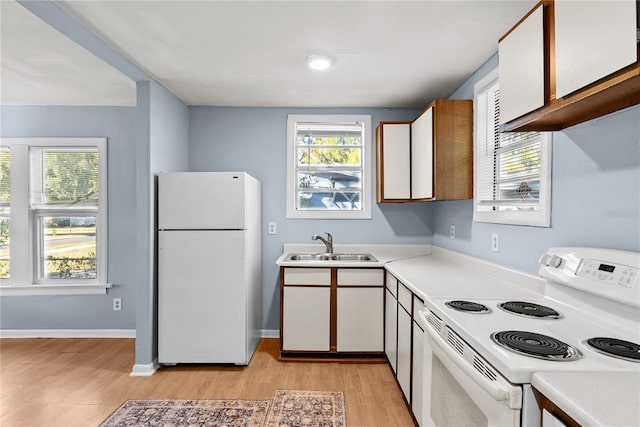 kitchen featuring sink, white cabinets, light hardwood / wood-style floors, and white appliances