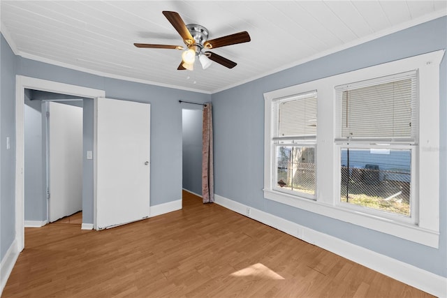 unfurnished bedroom with ceiling fan, hardwood / wood-style floors, and ornamental molding