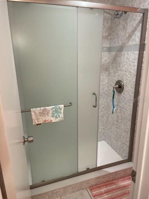 bathroom featuring tile patterned flooring and an enclosed shower