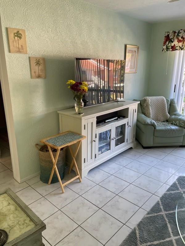 4199 38th Ave S Unit I, Saint Petersburg, FL 33711 - living room featuring light tile patterned floors and a textured wall