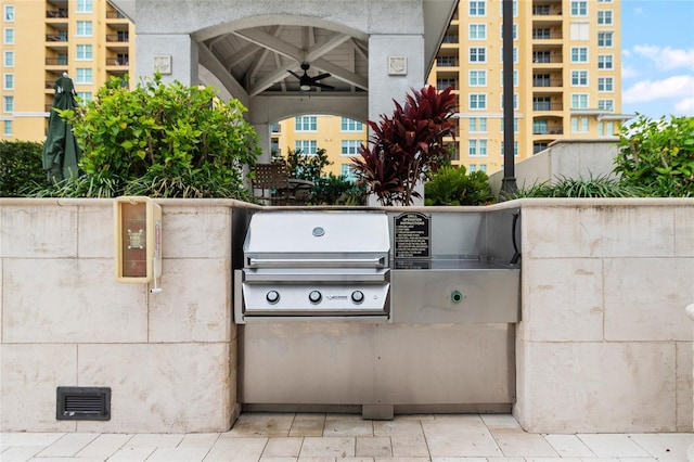 view of patio / terrace with a grill, ceiling fan, and an outdoor kitchen