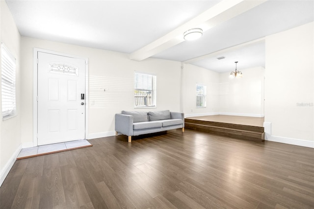 entrance foyer featuring dark hardwood / wood-style floors, beam ceiling, and a notable chandelier