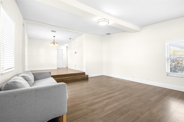 living room with dark hardwood / wood-style flooring, a notable chandelier, and beamed ceiling