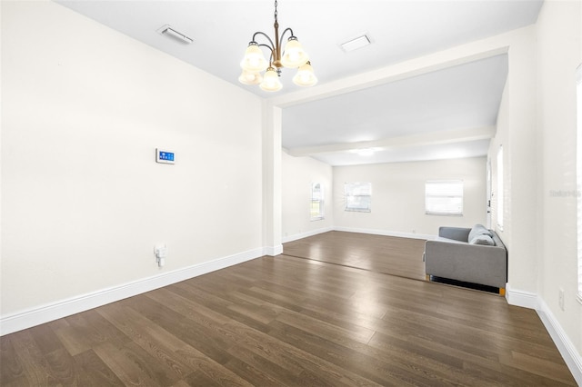 unfurnished living room with dark hardwood / wood-style floors, a chandelier, and beam ceiling